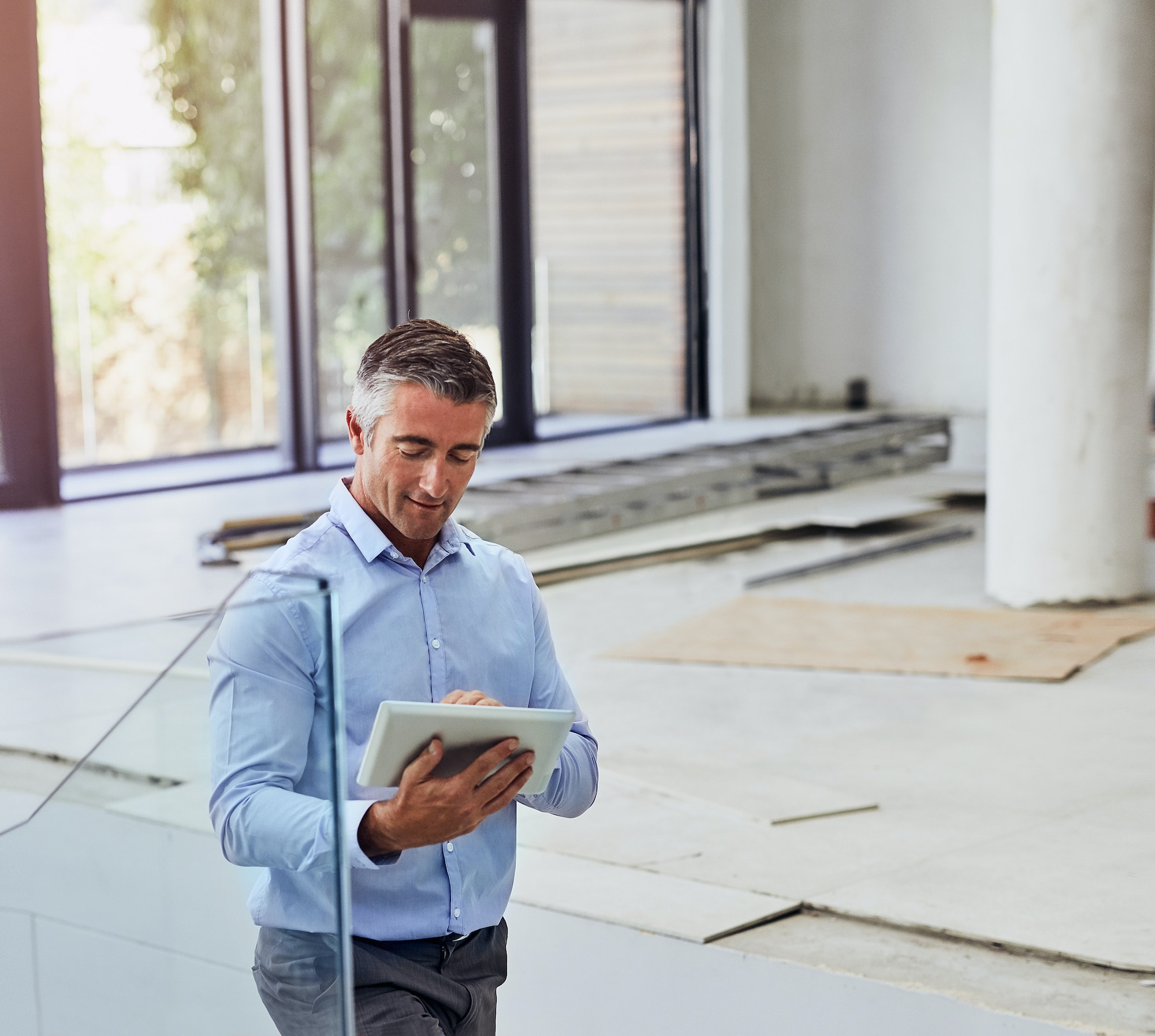 Shot of a foreman doing an inspection of a building while using his tablett